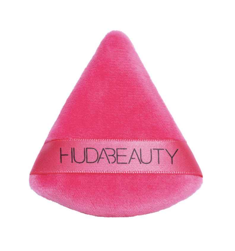 Pink triangular makeup puffs by Huda Beauty,  designed for precise application.